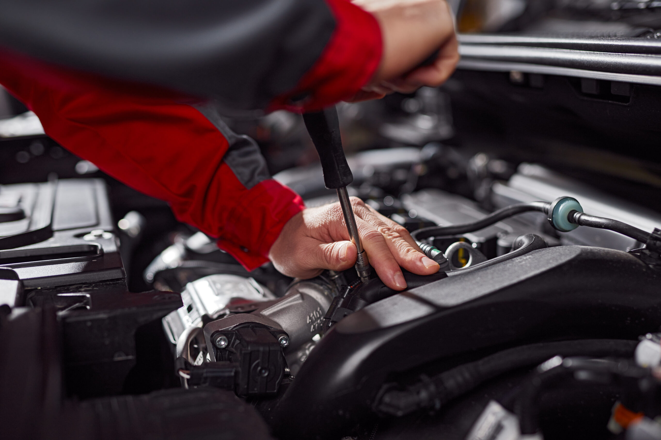 Motor bölmesinde bakım ve onarım yapan teknisyen